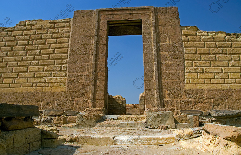 Karanis Southern Temple 6456EG07JHP 
 Karanis Kom Aushim Egypt Southern Temple Gateway Entrance Granite was a city on the north eastern edge of the area known as Fayoum and dates from Ptolemaic times through to 500AD. Two Roman dated temples survive in reasonable state and the southern one, the entrance gates shown in this photo is dedicated to the crocodile Gods of Pnepheros and Petesuchos. Many finds have been made especially of life in a residential area with houses scattered throughout the site and there is also a fine Roman bathhouse. A small museum now closed has ben replaced with an open air area with a selection of artefacts adjacent to the main walk to the temples. 
 Keywords: Egypt, Egyptian, Egyptology, upright, Karanis, Kom Aushim, el-Fayoum, Faiyum, Fayyum, Nero, Claudius, Vespasiun, Roman Emperors, South temple, outer, wall, construction, entrance, gate, foundations, gods, crocodile, dedicated, local, Pnepheros, Petesouchus, desert, sand