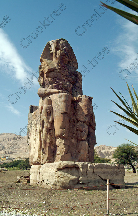 Colossi of Memnon EG020146jhp 
 Colossi Memnon ancient Egyptian West Nile seated statue Amenhotep Queen that are the most famous remains of his mortuary temple on the northern side of the approach road for the Valley of the Kings, Queens and all the other main West Bank sites. It is the visitors first site of major impact, not far from the main ticket office but is usually visited as a photo opportunity on leaving - recent excavations of the site are finding many hidden buildings and artefacts. see Victorian collection for similar viewpoint. 
 Keywords: Egypt, Egyptian, Luxor, West Bank, Thebes, Theban, hills, River Nile, Colossi of Memnon, seated, statues, Amenhotep, Pharaoh, side, Queen, standing, relief, union, upper, lower, Hapi, tying, lotus, papyrus, upright, history, archaeology, ancient, then, now, Victorian, Beato, Egyptology, temple, roadside, coachstop, excavations, farmland