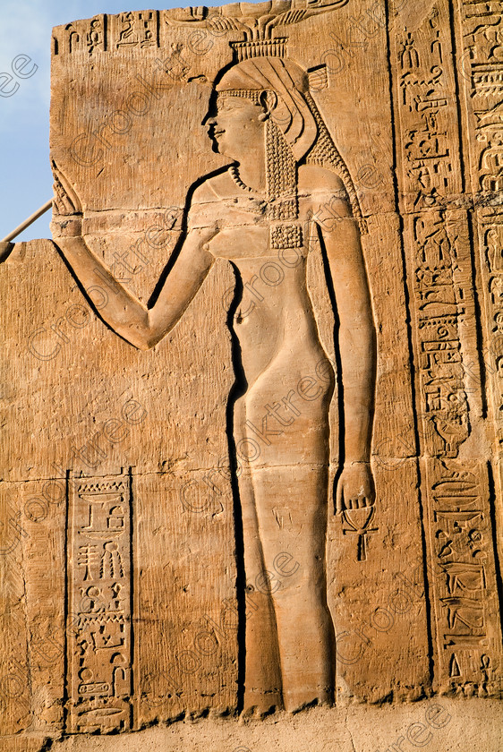 Kom Ombo Isis EG053177JHP 
 Kom Ombo Egyptian Temple Carving Goddess Isis Naked Ankh Atef Headdress on the River Nile just north of Aswan and a regular visit on all Nile Cruises, was principally built by Ptolemy V of Silsilah sandstone. Dedicated to two Gods Sobek, the crocodile and Horus, the falcon and although it has been damaged over the years, mainly through slipping into the River Nile and some structural damage owing to earthquakes, there are still some wonderful colourful reliefs of the most detailed and delicate style. 
 Keywords: Egypt, East Bank, River Nile, Kom Ombo, Temple, hypostyle hall, pylon, columns, bas reliefs, coloured, colored, colours, colors, Silsilah, sandstone, upright, hieroglyphs, ankh, history, archaeology, ancient, Egyptian, Egyptology, Ptolemaic, Isis, Hathor, carvings, detailed, delicate, beautiful, fine
