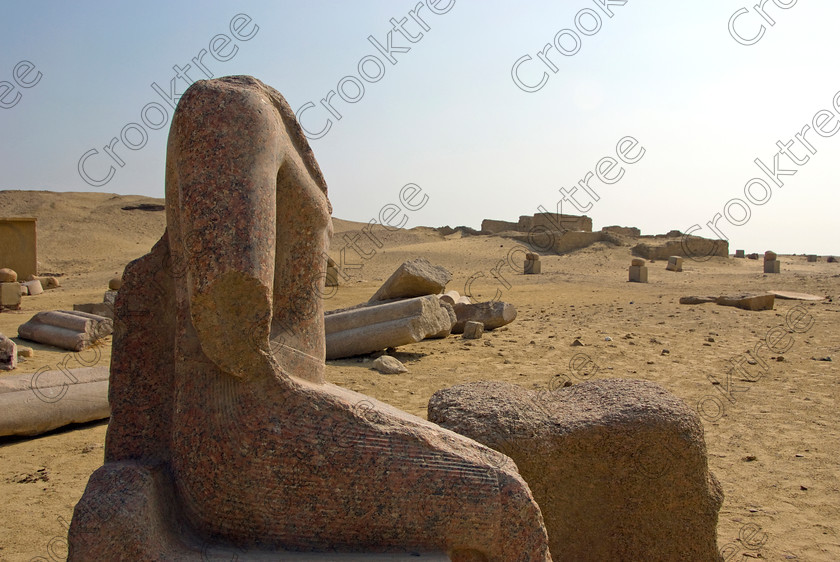 Karanis Open Air Museum 6429EG07JHP 
 Karanis Kom Aushim Ancient Egyptian City Fayoum Statue Exhibit Pharaoh on the north eastern edge of the area known as Fayoum and dates from Ptolemaic times through to 500AD. Two Roman dated temples survive in reasonable state and the southern one is dedicated to the crocodile Gods of Pnepheros and Petesuchos. Many finds have been made especially of life in a residential area with houses scattered throughout the site and there is also a fine Roman bathhouse. A small museum now closed has been replaced with an open air area with a selection of artefacts adjacent to the main walk to the temples as illustrated in this photo. 
 Keywords: Egypt, Egyptian, Egyptology, ancient, landscape, Karanis, Kom Aushim, open air museum, granite, red, statue, seated, broken, el-Fayoum, Faiyum, Fayyum