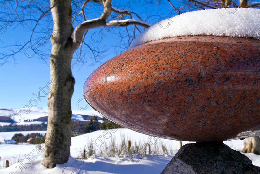 Lumsden Polished Sculpture TO172033JHP 
 Lumsden Outdoor Sculpture Red Granite Winter Snow Sunshine Photo Aberdeenshire Scotland a village on the A97 north of Kildrummy on the road to Huntly with a Sculpture Walk showing work of local artists from Workshop established in this community. 
 Keywords: Scotland, Scottish, Grampian, Aberdeenshire, Strathdon, Lumsden, sculptures, workshop, landscape, polished, winter, snow, red, granite, stone, trees, closeup