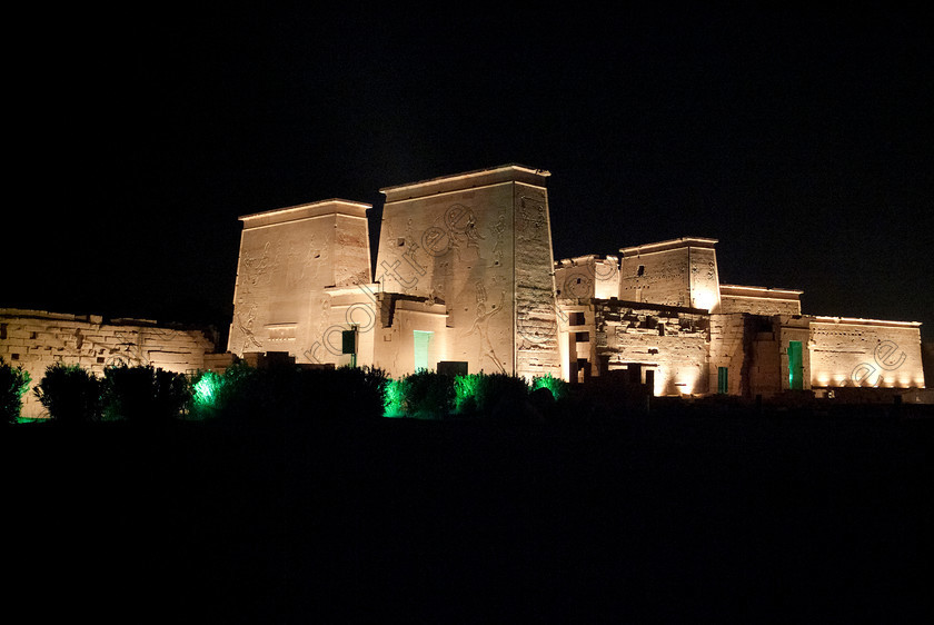 Philae Light Show EG052903JHP 
 Ancient Philae Temple Light Show Pylons Exterior Night Dark Coloured Colourful Aswan in which, during the first section, spectators walk through the temple with areas highlighted at each stop but the time to take photographs is limited. The second part of the evening is seated and photography is very easy, a tripod is permitted and necessary for time exposures to be made as flash on cameras is almost pointless and more of a nuisance for other viewers. This Sound & Light Show is perhaps the most spiritual of those shown at other centres especially with the trip at night by boat to the island and the peacefulness that naturally surrounds this location. 
 Keywords: Egypt, Egyptian, Aswan, River Nile, Agilkia Island, island, Philae, temple, light, sound, show, landscape, pylons, colonnade, court, entrance, Son, Lumiere, spectacular, fantasy, dramatic, night, dark, stars, colours, colors, colourful, colorful, spiritual, surreal