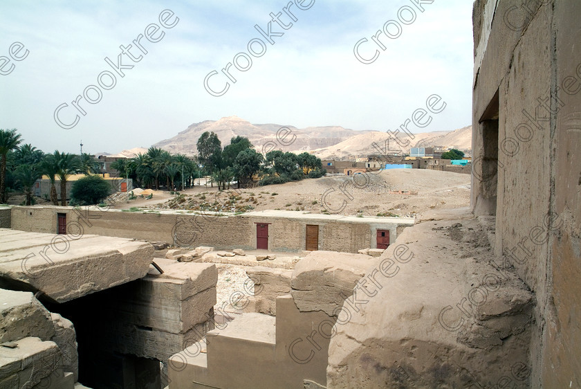 Seti 1 Temple EG053399JHP 
 Temple Sethos Roof View Theban Hills Qurna al-Tarif Goorneh Egypt on the West Bank of the River Nile at Luxor in an area called al-Tarif turning off eastwards instead of taking the Valley of the Kings road. Attributed to Seti it had involvement by Ramasses 1 and 11 and with recent restoration is a delightful extra addition should you have free time while in Luxor and described in the early days as Goorneh Temple. 
 Keywords: Egypt, Luxor, Thebes, River Nile, West Bank, Tarif, village, Temple, Sethos, Seti, Sety, Ramses, mortuary, Dra Abu el-Naga, Qurna, Goorneh, landscape, roof, view, high, hills, houses, trees, necropolis, sandstone, wall, coloured, colours, colors, history, archaeology, ancient, Egyptian, Egyptology, decorated