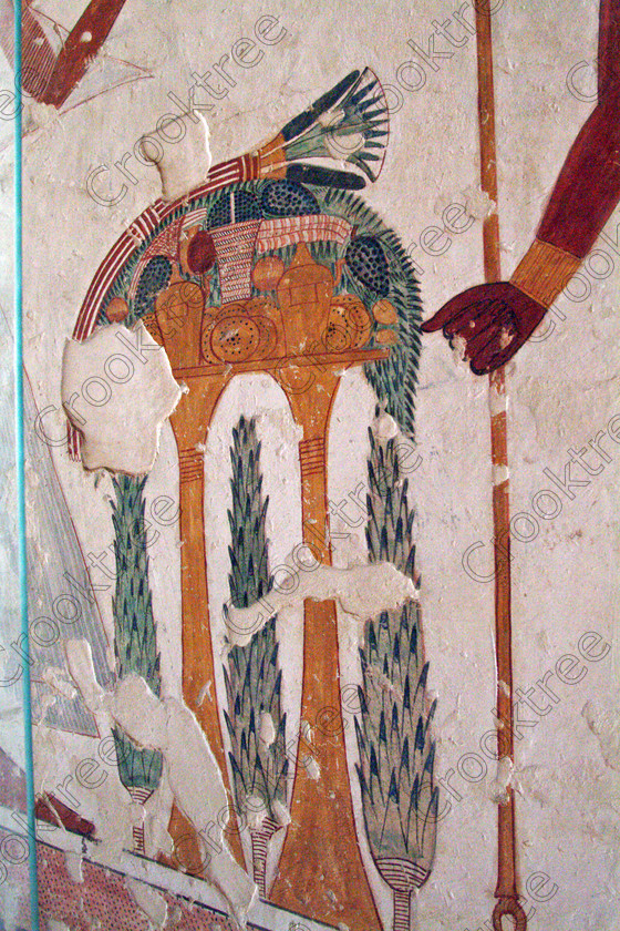 Valley Kings EG0213042jhp 
 Egypt Tomb KV19 Prince Montu-hir-Khopshef offering table fruit painting colors was son of Ramasses 1X, but his tomb was unfinished but has some excellent colourful depictions of the important ancient Egyptian Gods and although protected by Perspex panels, the custodian was very helpful and slid them back for me to take photographs in 2002 when it was still allowed. Thanks to the capability of the modern digital camera, the first and only chance I have had to use one, a Fuji S2 as photography is now banned in the Valley of Kings per se and especially in the tombs. Adjustments in Photoshop give the chance of reasonably accurate colours even when the tomb paintings were lit by low level artificial light when tripods and flash were not allowed; what could I get with a Nikon F700 and a tripod, which were allowed at one time as well. 
 Keywords: Egypt, Luxor, West Bank, Thebes, Theban, Valley Kings, prince, tomb, KV19, Montu, Mentuherkhepshef, Montu-hir-Khopshef, upright, paintings, colourful, colorful, colours, colors, bright, white, plaster, ancient, Egyptian, archaeology, Egyptology, hieroglyphics, death, burial, mythology, afterlife, history, hieroglyphs, Gods, offering, fruit, flowers, wine, grapes, bread, DSLR, Fuji, S2, handheld, artificial, light, Photoshop, adjusted, corrections, Perspex, screens