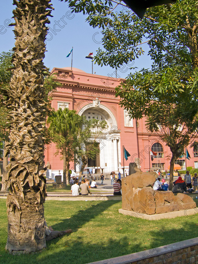 Cairo Egyptian Museum EG072607jhp 
 Egyptian Museum entrance Cairo trees palms seats design style Mariette founder is the prime antiquities collection in Cairo and of ancient Egypt in the world. These photos were taken through the roadside railings as cameras were banned then and that probably applies today as well. Unlike the British Museum in London where photography is allowed and even flash can be used, the Egyptian Museum and many others throughout the country have a total ban on photography and the reason being probably more to do with managing the huge crowds than one would hope is not to do with selfishness or the usual damaged caused by flash syndrome, a total red herring if ever there was one. 
 Keywords: Egypt, Cairo, Egyptian, Museum, Mariette, Maspero, upright, collection, huge, comprehensive, discovery, excavations, ancient, antiquity, antiquities, archaeology, architecture, iconic, exhibits, pond, feature, entrance, sphinx, seats, photography, ban, no cameras, flagpoles, capital, city