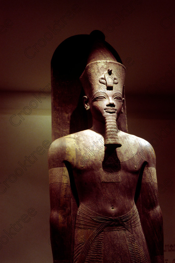Luxor Amenhotep Body EG9620926JHP 
 Egyptian Amenhotep Pharaoh Statue Red Quartzite Museum Luxor Cache Standing was photographed inside this modern building on the waterfront of the River Nile with its fascinating collection covering the extensive history of ancient Egypt including items from the Tomb of Tutankahum. These particular exhibits are in an annex displaying statues discovered in 1989 in a storage pit and called The Luxor Temple Cachette of which the red quartzite life size statue of Amenhotep 111 is one of the finest pieces of carving yet found in Egypt. This photo was taken in 1996 when you could pay to take photographs but not use a tripod, now not allowed at all, and I used Kodak 5042 Tungsten Slide film which still meant hand holding was at the extremes of useful photography in low light conditions. 
 Keywords: Egypt, Egyptian, Luxor, East, Bank, River, Nile, Museum, Cache, Cachette, Temple, Interior, Statue, upright, standing, history, archaeology, Egyptology, exhibit, Pharaoh, Amenhotep, Amenophis, red, quartzite, carved