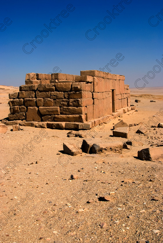 Qasr al-Saghah Temple 6594EG07JHP 
 Qasr al-Saghah Temple Desert Egypt Ancient Construction Workers Photo is a small late 12th century Egyptian worker's temple, unfinished and uninscribed near the Gebel el-Qatrani worker’s town servicing the basalt mines to the west of Lake Qarun and accessible only by 4x4 on specialist tours of Egypt. It is constructed of dark brown calciferous sandstone with seven cult shrines facing a common offering table room with the probable front of the temple never finished. 
 Keywords: Egypt, Egyptian, Egyptology, al-Siba, Qasr el-Sagha, al-Saghah, Es-Saghah, Temple, seven, cult, shrines, crypt, offering, table, room, Sobek, archaeology, ancient, history, upright, desert, safari, calciferous, sandstone, sand, blistering, heat, sun, blue, sky, eroded, stones, foreground, hills, stratified, erosion