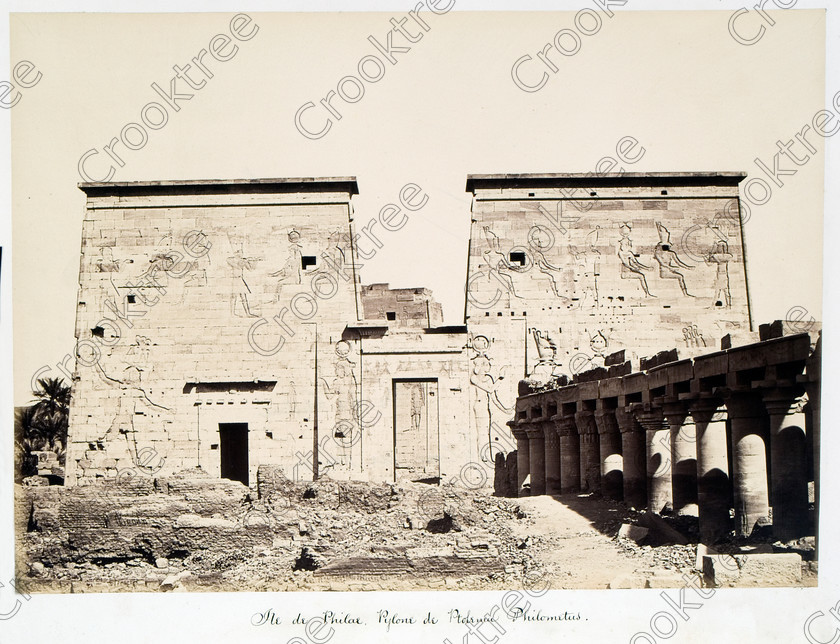 Beato Philae Temple 26JHP05 
 Ancient Egyptian Philae Temple First Pylon Beato Old Photograph Albumen Print on its original island location in the River Nile, dedicated to the Goddess Isis and here photographed by Antonio Beato, a Victorian photographer around 1890 and this copy is taken from his album called The Nile 1872. The mudbrick ruins have all been removed since this photograph and this view is completely open as seen in modern images in the Philae Temple gallery. 
 Keywords: Egypt, Aswan, Nubia, River Nile, Philae, Temple, Island, Isis, pylon, colonnade, water, history, antiquity, Egyptian, ancient, archaeology, Egyptology, landscape, Antonio Beato, Victorian, photographer, earliest, albumen, print, copy