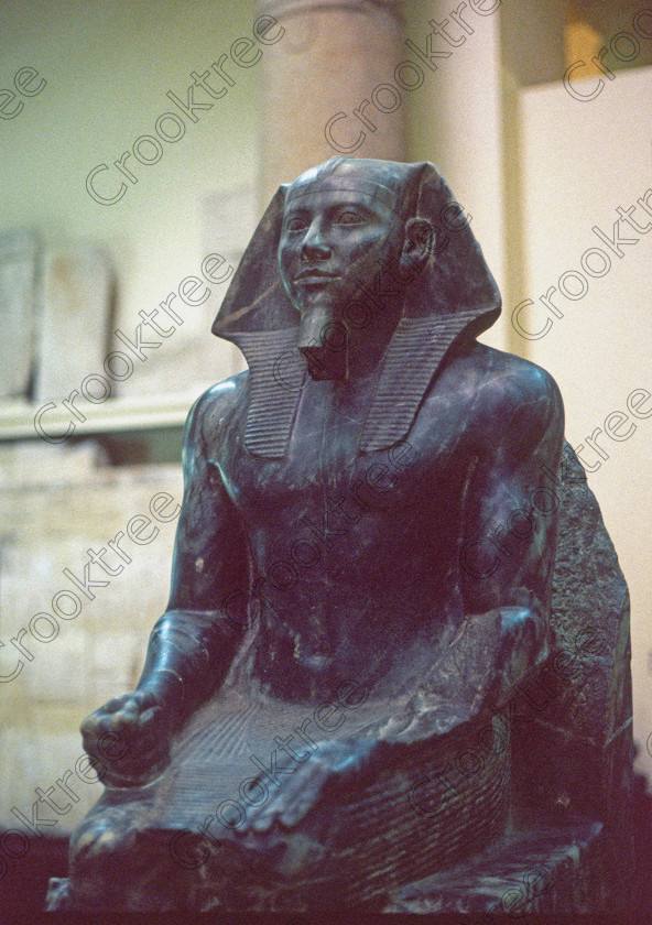 Diorite Khafre EG11824JHP 
 Egyptian Museum Cairo Exhibit Pharaoh Khafre ground floor inside photograph in the prime antiquities collection in Cairo taken during visits between 1994 and 1996 when photography was allowed albeit without flash and tripod. None is of studio quality, being handheld with existing, usually extremely poor light and using slide film, pushed Fuji 400asa to get a suitable aperture and shutter speed. Most of the photos are from the Tutankahum exhibits while the rest are items that interested me as I explored this wonderful and extensive collection, requiring many more hours if not days and is only hinted at during the usual one or two hour visit made on a package tour. 
 Keywords: Egypt, Cairo, Egyptian, Museum, diorite, Khafre, seated, statue, pharaoh, ground, floor, collection, upright, ancient, antiquity, antiquities, exhibit