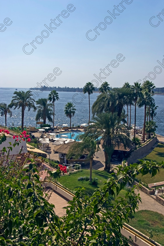 Luxor River Nile EG075093jhp 
 Egypt Luxor Sheraton Hotel River Nile View balcony West Bank south looking over the shimmering River Nile on a sunny autumn afternoon from one of the riverside balconies of this long standing International Hotel on the southern outskirts of the east bank city. 
 Keywords: Egypt, Thebes, Luxor, Waset, Ipetisut, East, Bank, River, Nile, Sheraton, Hotel, riverside, riverbank, upright, palm, trees, water, shimmering, autumn, sunshine, blue, sky, hazy, West, bank, waterfront, promenade, esplanade, modern, architecture, swimming, pool, poolside, style, stylish, balconies, balcony, tree-lined