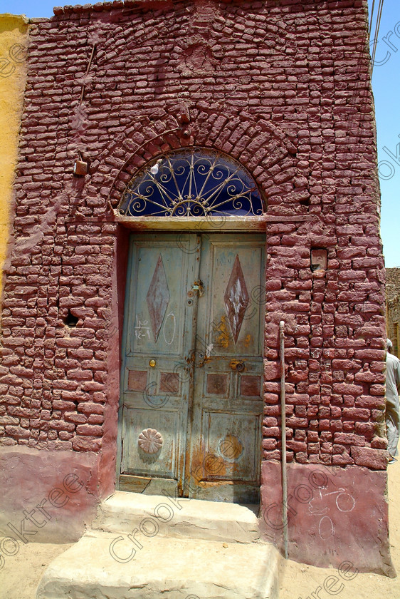Seheil Nubian Doorway EG052673JHP 
 Seheil Island Aswan Nubian Village Street Doorway Painted Bricks photo with its genuine sense of colour and distinctive desert shapes for buildings that remain cool in the heat of southern Egypt on this island near Aswan amongst the River Nile cataracts. The main reason for this private excursion by motorboat was to visit the rock carvings which cover this boulder strewn part of the Nile recording many events throughout the ancient history of the Egyptian Empire spanning some 3000 years. 
 Keywords: Egypt, Aswan, River Nile, Seheil, Sehel, Island, Nubia, Nubian, village, natural, houses, homes, domestic, door, decorated, street, upright, Egyptian, colours, colors, colourful, colorful, painted, bricks, mudbrick, wrought-iron, architecture