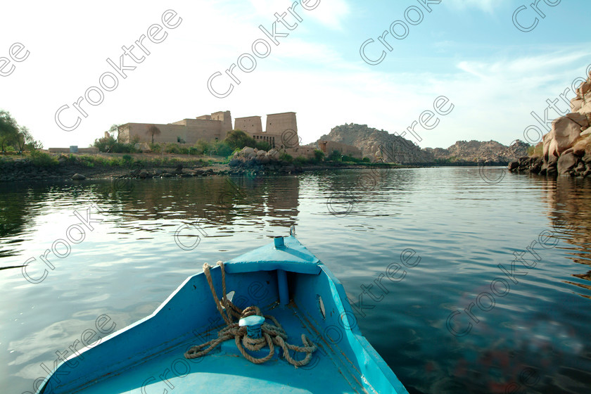 Philae Temple Approach EG02506JHP 
 Philae Temple Island Agilkia Motorboat Bow Water Approach Travel Photo to visit the home of the Goddess Isis was established late in the history of Egypt being mainly Ptolemaic, eventually closing as a religious site around 550AD and being located on an island had remained remarkably untouched. Being relocated onto the Island of Agilkia on the River Nile near Aswan, to save it being flooded after the completion of the High Dam, it is perhaps one of the loveliest and most complete classic Egyptian temples to visit with a peaceful spirituality lacking in many of the land based sites. 
 Keywords: Egypt, Aswan, River Nile, Nubia, Philae Temple, island, pylons, landscape, history, ancient, Egyptian, antiquity, archaeology, Egyptology, Agilkia Island, motorboat, water