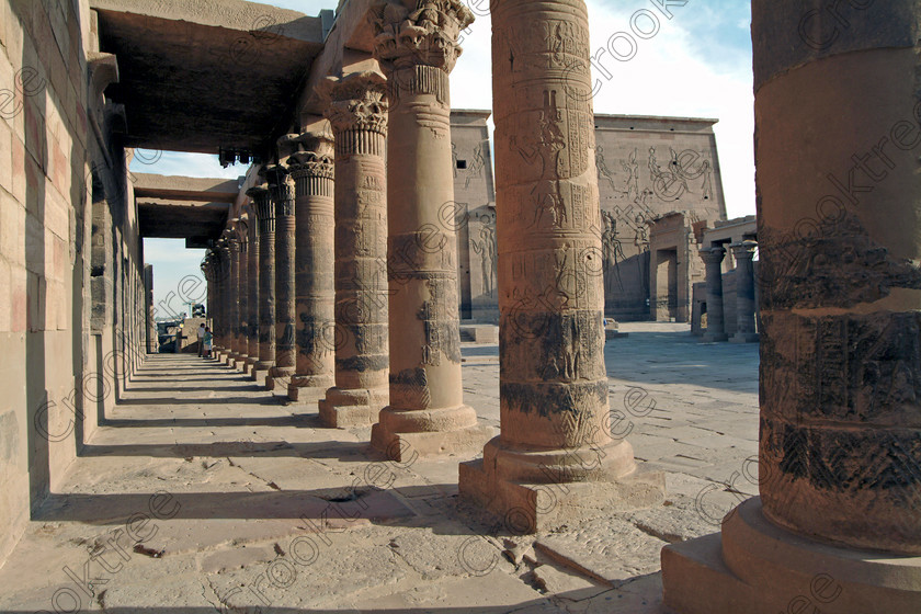 Philae Temple Colonnade EG02509JHP 
 Philae Temple Photograph West Colonnade View Courtyard Entrance Columns Aswan Island home of the Goddess Isis was established late in the history of Egypt being mainly Ptolemaic, eventually closing as a religious site around 550AD and being located on an island had remained remarkably untouched. Being relocated onto the Island of Agilkia on the River Nile near Aswan, to save it being flooded after the completion of the High Dam, it is perhaps one of the loveliest and most complete classic Egyptian temples to visit with a peaceful spirituality lacking in many of the land based sites. 
 Keywords: Egypt, Aswan, River Nile, Nubia, Philae Temple, island, pylon, first, court, colonnade, western, columns, hieroglyphs, Ptolemy, Ptolemaic, landscape, history, ancient, Egyptian, antiquity, archaeology, Egyptology, Agilkia Island, motorboat, water
