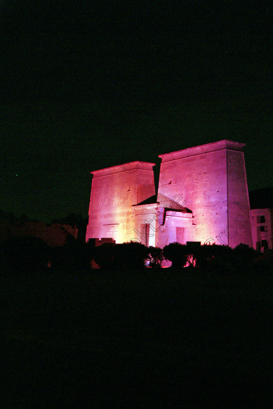 Aswan Philae Light Show EG02948jhp 
 Philae Temple Light Sound Aswan Egypt coloured pylon pink night in which, during the first section, spectators walk through the temple with areas highlighted at each stop but the time to take photographs is limited. The second part of the evening is seated and photography is very easy, a tripod is permitted and necessary for time exposures to be made as flash on cameras is almost pointless and more of a nuisance for other viewers. This Sound & Light Show is perhaps the most spiritual of those shown at other centres especially with the trip at night by boat to the island and the peacefulness that naturally surrounds this location. 
 Keywords: Egypt, Aswan, River, Nile, Nubia, Agilkia, Philae, Temple, upright, first, pylon, pylons, Trajan, Kiosk, stele, Ptolemaic, Island, Sound, Light, Son, Lumiere, surreal, experience, spectacular, fantasy, dramatic, colours, colors, pink, red, colourful, colorful, history, antiquity, ancient, Egyptian, walk, through, sitting, dark, night, stars, holiday, travel, tourists, tourism, boat, water, Egyptology, entrance, courtyard, colonnades, 2002, Fuji, S2, DSLR
