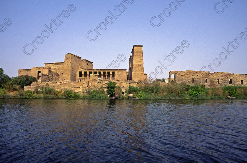 Philae Temple EG204523jhp 
 Philae Temple Pylons Osiris Chapel Mammisi Egypt Agilkia boat view island was established late in the history of Egypt being mainly Ptolemaic, eventually closing as a religious site around 550AD and being located on an island had remained remarkably untouched, partly as it was submerged when the Nile flooded after the construction of the first dam. Being relocated onto the Island of Agilkia on the River Nile near Aswan, to save it being flooded permanently after the completion of the High Dam, it is perhaps one of the loveliest and most complete classic Egyptian temples to visit with a peaceful spirituality lacking in many of the land based sites mainly because of being isolated on an island from modern day noise and often being less crowded as less accessible. It also has a very delightful Light and Sound show, partly a walk through to the Sanctuary followed by a sit down session just past the Kiosk of Trajan. 
 Keywords: Egypt, Aswan, River Nile, Nubia, Philae Temple, island, water, view, pylons, carvings, Ptolemy, Ptolemaic, Isis, cult, relocated, rescued, High Dam, landscape, history, ancient, Egyptian, antiquity, entrance, pylon, first, Ptolemy, second, granite, stele, year, 24, Philometer V11, mammisi, birth, house, chapel, kiosk, Trajan, lion, colonnade, columns, Roman, archaeology, Egyptology, Agilkia, Island, gate, Diocletian, Augustus, temple, Hathor, steps, motorboat, beautiful, serene, peaceful, oleander, flowering, flowers, July, 2000, slide, film, Fuji, Velvia, Nikon, FM2, FG20, manual, 35mm, scanned, scan