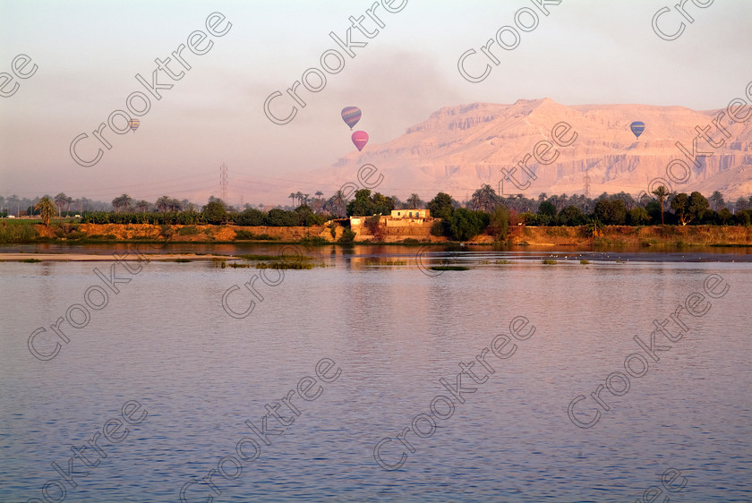 Balloons Over Luxor EG053605JHP 
 Luxor River Nile Hot Air Balloons Dawn Mist Egypt Theban taken from the east bank at the Nile Romance berth on the morning of departure from a Nile cruise and a regular morning site as visitors glide over the west bank. 
 Keywords: Egypt, Egyptian, Luxor, West Bank, East Bank, Thebes, Theban, hills, balloons, dawn, mist, water, landscape, hot, air, flying, climbing, soaring