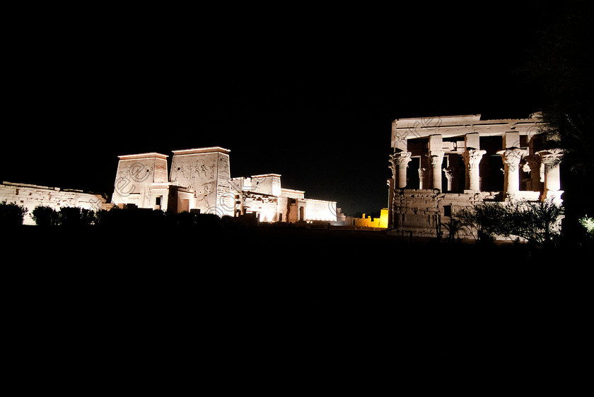 Philae Light Show EG052896JHP 
 Philae Temple Light Show Panorama Kiosk Pylons Sanctuary Nile Island Aswan in which, during the first section, spectators walk through the temple with areas highlighted at each stop but the time to take photographs is limited. The second part of the evening is seated and photography is very easy, a tripod is permitted and necessary for time exposures to be made as flash on cameras is almost pointless and more of a nuisance for other viewers. This Sound & Light Show is perhaps the most spiritual of those shown at other centres especially with the trip at night by boat to the island and the peacefulness that naturally surrounds this location. 
 Keywords: Egypt, Egyptian, Aswan, River Nile, Agilkia Island, island, light, Philae, temple, pylons, Trajan, kiosk, sound, show, upright, landscape, colonnade, court, entrance, Son, Lumiere, spectacular, fantasy, dramatic, night, dark, stars, colours, colors, colourful, colorful, spiritual, surreal