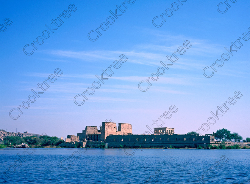 Philae from Nile SS98235JHP 
 Philae Temple Agilkia Island Distance Approach Motorboat Pylons Kiosk Aswan Egypt perhaps as it would have been viewed from a passing sailing boat now of course part of the flooded areas created by the British and High Dam's but still one of the most spiritual visits on the Nile cruise itinerary. 
 Keywords: Egypt, Aswan, River Nile, Nubia, Philae temple, pylon, landscape, history, ancient, Egyptian, antiquity, archaeology, Egyptology, Agilkia Island, motorboat, water