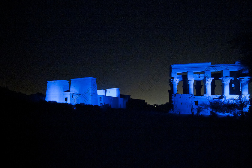 Philae Light Show EG052894JHP 
 Philae Temple Trajan Kiosk Blue Light Show Vista Aswan Island Agilkia in which, during the first section, spectators walk through the temple with areas highlighted at each stop but the time to take photographs is limited. The second part of the evening is seated and photography is very easy, a tripod is permitted and necessary for time exposures to be made as flash on cameras is almost pointless and more of a nuisance for other viewers. This Sound & Light Show is perhaps the most spiritual of those shown at other centres especially with the trip at night by boat to the island and the peacefulness that naturally surrounds this location. 
 Keywords: Egypt, Egyptian, Aswan, River Nile, Agilkia Island, island, Philae, temple, pylons, Trajan, kisok, light, sound, show, landscape, colonnade, court, entrance, Son, Lumiere, spectacular, fantasy, dramatic, night, dark, stars, blue, colours, colors, colourful, colorful, spiritual, surreal
