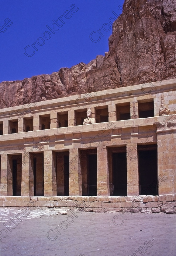 Hatshepsut Luxor EG20645jhp 
 Hatshepsut Temple terrace cliffs statues Egyptian Queen Pharaoh Thebes mortuary and beyond this the Upper central court was opened again in 2002 and makes the visit to this magnificent temple almost complete except that entrance into the burial chamber itself is restricted. This magnificent mortuary temple is located on the West Bank of the River Nile at Luxor at an area called Deir el-Bahri and built into the base of the cliffs of the Theban Hill behind which are branches of the Valley of the Kings. 
 Keywords: Egypt, Luxor, Thebes, Theban, West Bank, Deir el-Bahri, el-Bahari, Dayr, Hatshepsut, mortuary, Temple, upright, landscape, upper, terrace, head, face, colours, colors, painted, red, statues, archaeology, ancient, Egyptian, history, Egyptology, Consort, Queen, Pharaoh, Royal, ruler, woman, columns, 2000, July, summer, 35mm, slide, film, Velvia, RVP, scanned, scan, camera, Nikon, FM2