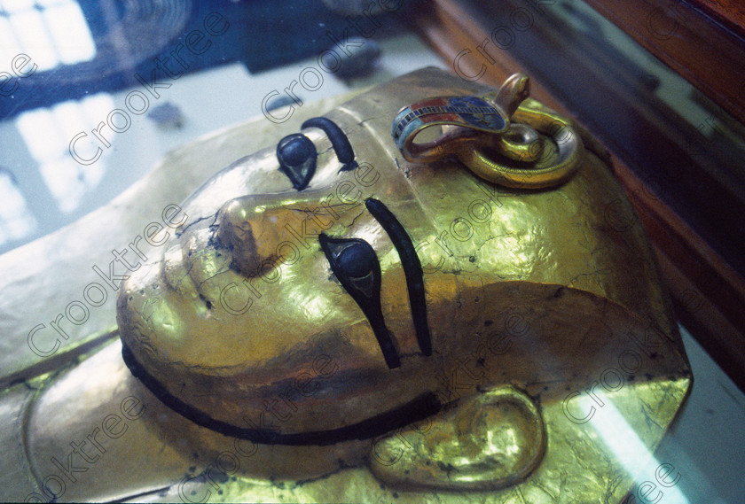 Gilded Coffin Face EG11801JHP 
 Egypt Cairo Museum golden gilded sarcophagus face mummy coffin Tut in the prime antiquities collection in Cairo taken during visits between 1994 and 1996 when photography was allowed albeit without flash and tripod. None is of studio quality, being handheld with existing, usually extremely poor light and using slide film, pushed Fuji 400asa to get a suitable aperture and shutter speed. Most of the photos are from the Tutankahum exhibits while the rest are items that interested me as I explored this wonderful and extensive collection, requiring many more hours if not days and is only hinted at during the usual one or two hour visit made on a package tour. 
 Keywords: Egypt, Cairo, Egyptian, Museum, gilded, coffin, sarcophagus, face, uraeus, eyes, collection, landscape, ancient, antiquity, antiquities, exhibit