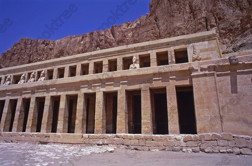 Hatshepsut Luxor EG20646jhp 
 Hatshepsut Temple terraces cliffs statues Egypt Queen Pharaoh Theban hill mortuary and beyond this the Upper central court was opened again in 2002 and makes the visit to this magnificent temple almost complete except that entrance into the burial chamber itself is restricted. This magnificent mortuary temple is located on the West Bank of the River Nile at Luxor at an area called Deir el-Bahri and built into the base of the cliffs of the Theban Hill behind which are branches of the Valley of the Kings. 
 Keywords: Egypt, Luxor, Thebes, Theban, West Bank, Deir el-Bahri, el-Bahari, Dayr, Hatshepsut, mortuary, Temple, landscape, upper, terrace, head, face, colours, colors, painted, red, statues, archaeology, ancient, Egyptian, history, Egyptology, Consort, Queen, Pharaoh, Royal, ruler, woman, columns, 2000, July, summer, 35mm, slide, film, Velvia, RVP, scanned, scan, camera, Nikon, FM2