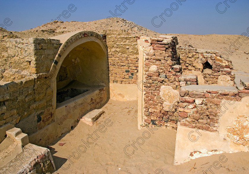 Karanis Roman Bath 6483EG07JHP 
 Karanis City Kom Aushim Roman Bath House Decoration Sand Desert was a city on the north eastern edge of the area known as Fayoum and dates from Ptolemaic times through to 500AD. Two Roman dated temples survive in reasonable state and the southern one is dedicated to the crocodile Gods of Pnepheros and Petesuchos. Many finds have been made especially of life in a residential area with houses scattered throughout the site and there is also a fine Roman bath house as in this photo. A small museum now closed has ben replaced with an open air area with a selection of artefacts adjacent to the main walk to the temples. 
 Keywords: Egypt, Egyptian, Egyptology, ancient, landscape, Karanis, Kom Aushim, mudbrick, ruin, Nero, Claudius, Vespasiun, Roman, Emperors, town, bath-house, house, building, el-Fayoum, Faiyum, Fayyum, Lake Qarun, Moeris, sand, desert