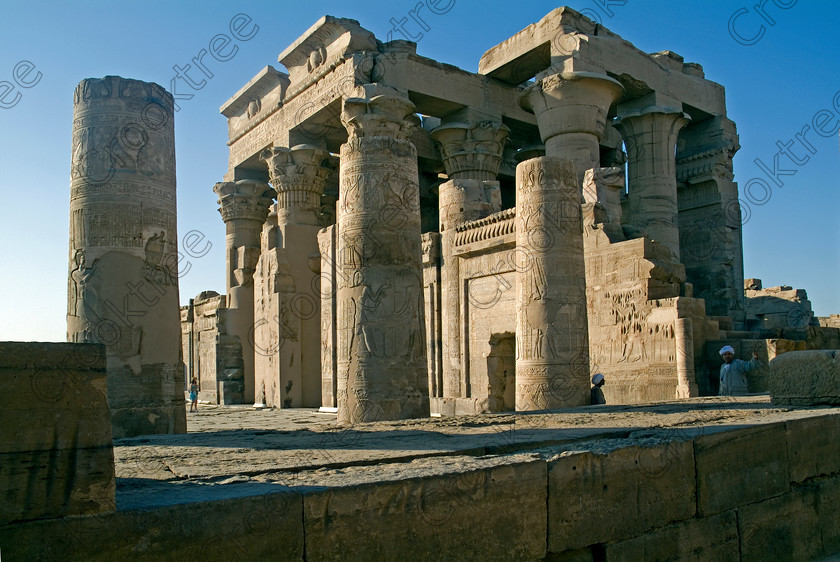 Kom Ombo Temple EG052509JHP 
 Kom Ombo Egyptian Ptolemaic Temple Hypostyle Hall Columns Capitals Floral on the River Nile just north of Aswan and a regular visit on all Nile Cruises, was principally built by Ptolemy V of Silsilah sandstone. Dedicated to two Gods – Sobek, the crocodile and Horus, the falcon and although it has been damaged over the years, mainly through slipping into the River Nile and some structural damage owing to earthquakes, there are still some wonderful colourful reliefs of the most detailed and delicate style. 
 Keywords: Egypt, East Bank, River Nile, Kom Ombo, Temple, hypostyle hall, lintels, solar, disc, floral, capitals, columns, bas reliefs, coloured, colored, colours, colors, Silsilah, sandstone, landscape, history, archaeology, ancient, Egyptian, Egyptology, Ptolemaic, Ptolemy, Horus, Haroeris, Harwer, Sobek, Hathor, carvings, detailed, delicate, beautiful, fine