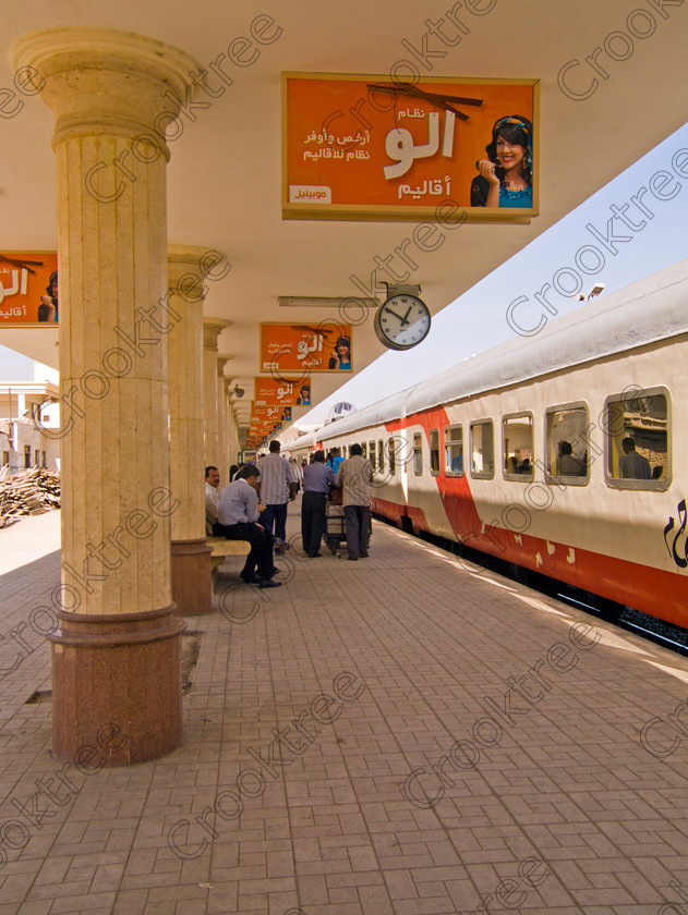 Luxor Station & Train EG072606jhp 
 Egypt Luxor Station platform train passengers modern architecture Egyptians found at the end of this long straight road Sharia al-Mahatta from just behind Luxor Temple and facing the elegant and modern railway station faade. We were dropped here before entering the station and boarding the main Aswan to Cairo train for a visit to the Minya area.
Although we travelled First Class and the seats were undoubtately some of the most comfortable I had had on a train the toilets were probably the worst I have ever experienced anywhere and given the importance of tourism to Egypt and the huge pool of labour available this was an unacceptable lack of standards. 
 Keywords: Egypt, Thebes, Luxor, Waset, Ipetisut, East, Bank, River, Nile, Sharia, al Mahatta, road, station, platform, train, railway, Ramses, waterfront, promenade, esplanade, upright, Corniche, modern, architecture, European, influence, style, stylish, balconies, Egyptian, theme, eye, wedjat, freize, cornice, construction, apartment, block, street, cars, people, tree-lined