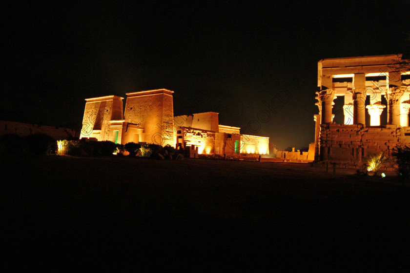 Aswan Philae Light Show EG02952jhp 
 Philae Temple Light Show Pylons Aswan Egypt Trajan Kiosk night in which, during the first section, spectators walk through the temple with areas highlighted at each stop but the time to take photographs is limited. The second part of the evening as illustrated in this photo is seated and photography is very easy, a tripod is permitted and necessary for time exposures to be made as flash on cameras is almost pointless and more of a nuisance for other viewers. This Sound & Light Show is perhaps the most spiritual of those shown at other centres especially with the trip at night by boat to the island and the peacefulness that naturally surrounds this location. 
 Keywords: Egypt, Aswan, River, Nile, Nubia, Agilkia, Philae, Temple, landscape, first, second, pylon, pylons, Trajan, Roman, Kiosk, stele, Ptolemaic, Island, Sound, Light, Son, Lumiere, surreal, experience, spectacular, fantasy, dramatic, colours, colors, colourful, colorful, history, antiquity, ancient, Egyptian, walk, through, sitting, dark, night, stars, holiday, travel, tourists, tourism, boat, water, Egyptology, entrance, courtyard, colonnades, 2002, Fuji, S2, DSLR