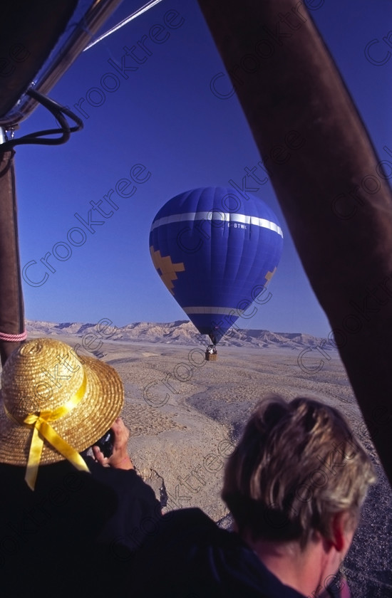 Luxor West Bank EG947629jhp 
 Luxor Nile Balloons flight soaring Western desert landing hills Egypt after passing the several famous temples situated on the West Bank location of the Nile at Luxor. Apart from the main sites visited, in this general area are several Tombs of the Nobles which are usually privately organised visits but very well worth the time if you have a few days to spare in Luxor. The balloon flight illustrated here was in 1994 and there were only two although in later years these increased greatly in numbers. This trip took off from the front of Hatshepsut just after dawn, a cold and interesting crossing of the Nile in the dark and long before the modern road bridge and eventually landed in the desert where the Hilton Hotel put on a beautiful breakfast buffet. I understand in recent times the breakfast has come to a boxed meal probably eaten on the bus journey back to the hotel or cruiseboat. 
 Keywords: Egypt, Egyptian, Luxor, Ramasseum, Temple, West, Bank, River Nile, Thebes, Qurnat, Murai, Shaykh 'Abd al-Qurnah, landscape, upright, people, history, archaeology, ancient, Egyptology, hieroglyphics, granite, Osiride, statue, broken, Shelley, Ozymandias, pylon, court, columns, base, hieroglyphs, Ramses, Ramasses, Ramesses, glowing, golden, sunlight, dawn, agriculture, farming, houses, tombs, Nobles, high, panorama, balloon, balloons, high, flying, soaring, 1994, slide, film, 35mm, format, scanned, scan, Nikon, FM2, manual