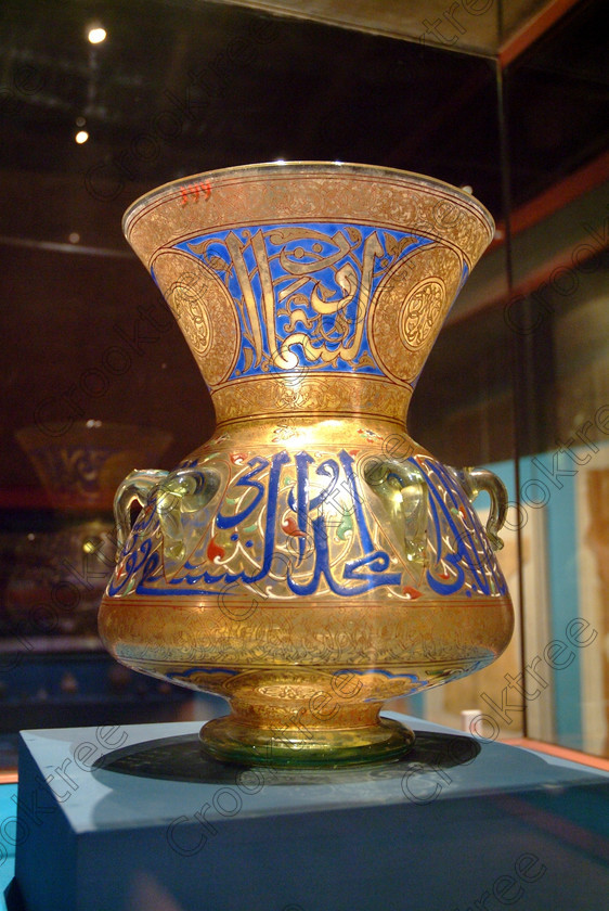 Aswan Nubian Museum Lamp EG052977JHP 
 Aswan Egyptian Nubian Museum Islamic Glass lamp in Mameluk style with enamelled naskhi test giving the Emir Qusun and his title from the Ottaman period and a specular example of the ancient craftmanship on show in this modern building whose foundations were laid in 1986, opened in 1997 and organised through UNESCO. Very low artificial light makes general photography difficult as well as affecting accurate colour balance. This now appears to be the only museum in Egypt where photography is still allowed although it is not easy as the ambient lighting is extremely subdued for conservation reasons. 
 Keywords: Egypt, Egyptian, Aswan, Nubian, Nubia, Museum, exhibit, glass, lamp, large, text, nashki, enamelled, inside, interior, ancient, Ottaman, Islamic, Mameluke, upright