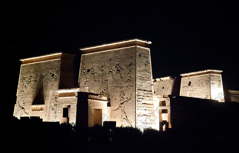 Philae Light Show EG052901JHP 
 Philae Temple Pylons Carved Etched Light Night Dark Show Aswan Photo in which, during the first section, spectators walk through the temple with areas highlighted at each stop but the time to take photographs is limited. The second part of the evening is seated and photography is very easy, a tripod is permitted and necessary for time exposures to be made as flash on cameras is almost pointless and more of a nuisance for other viewers. This Sound & Light Show is perhaps the most spiritual of those shown at other centres especially with the trip at night by boat to the island and the peacefulness that naturally surrounds this location. 
 Keywords: Egypt, Egyptian, Aswan, River Nile, Agilkia Island, island, Philae, temple, light, sound, show, landscape, pylons, colonnade, court, entrance, Son, Lumiere, spectacular, fantasy, dramatic, night, dark, stars, colours, colors, colourful, colorful, spiritual, surreal