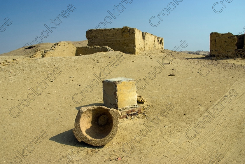 Karanis Fallen Quern 6434EG07JHP 
 Karanis Kom Aushim Quern Broken Exhibits Desert Fayoum Egypt Photograph Open Air Museum walk to this ruined city on the north eastern edge of the area known as Fayoum and dates from Ptolemaic times through to 500AD. Two Roman dated temples survive in reasonable state and the southern one is dedicated to the crocodile Gods of Pnepheros and Petesuchos. Many finds have been made especially of life in a residential area with houses scattered throughout the site and there is also a fine Roman bathhouse. A small museum now closed has been replaced with an open air area with a selection of artefacts such as this fallen quern or stone griding bowl adjacent to the main walk to the temples. 
 Keywords: Egypt, Egyptian, Egyptology, ancient, landscape, Karanis, Kom Aushim, open air museum, quern, grinding, flour, grain, bowl, fallen, plinth, carved, stone, jar, el-Fayoum, Faiyum, Fayyum