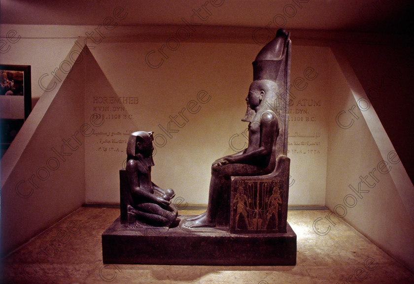 Luxor Cachette Statues EG9620918JHP 
 Egypt Egyptian Museum Luxor Cachette Horemheb Atum Seated Statues Photo were photographed inside this modern building on the waterfront of the River Nile with its fascinating collection covering the extensive history of ancient Egypt including items from the Tomb of Tutankahum. These particular exhibits are in an annex displaying statues discovered in 1989 in a storage pit and called The Luxor Temple Cachette of which the red quartzite life size statue of Amenhotep 111 is one of the finest pieces of carving yet found in Egypt. This photo was taken in 1996 when you could pay to take photographs but not use a tripod, now not allowed at all, and I used Kodak 5042 Tungsten Slide film which still meant hand holding was at the extremes of useful photography in low light conditions. 
 Keywords: Egypt, Egyptian, Luxor, East, Bank, River, Nile, Museum, Cache, Cachette, Temple, Interior, Statues, landscape, history, archaeology, Egyptology, exhibits, Horemheb, Pharaoh, seated, basalt, Atum, carved, figures, God
